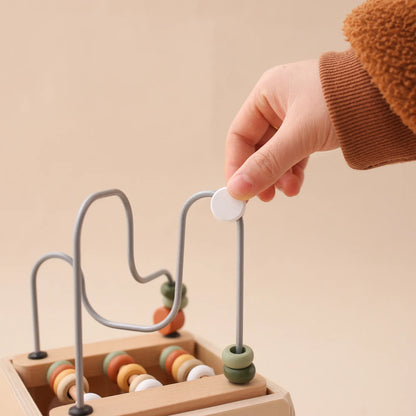 Toddler playing with wooden activity cube bead maze – Montessori toy for fine motor skills, UK preschool